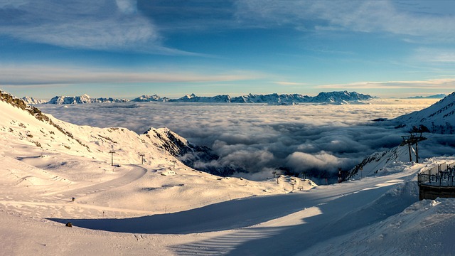 An image showcasing a snowy mountain landscape with a vibrant ski resort bustling with families enjoying skiing, snowboarding, ice skating, and sledding